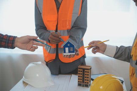 Construction and structure concept of Engineer or architect meeting for project working with partner and engineering tools on model building and blueprint in working site, contract for both companies.の写真素材