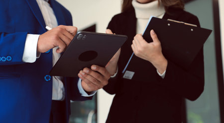Entrepreneur Asian businessman and businesswoman discussing new business project in tablet in modern...