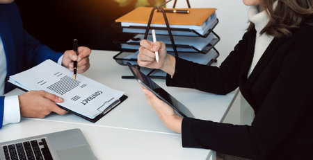 Entrepreneur Asian businessman and businesswoman discussing new business project in tablet in modern Meeting In Modern Office, Asian business casual concept.の写真素材