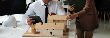 Construction and structure concept of Engineer or architect meeting for project working with partner and engineering tools on model building and blueprint in working site, contract for both companies.の写真素材