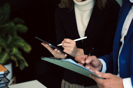 Entrepreneur Asian businessman and businesswoman discussing new business project in tablet in modern...