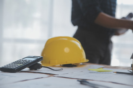 Close up of civil male engineer asian working on blueprint architectural project at construction site at desk in office.の写真素材