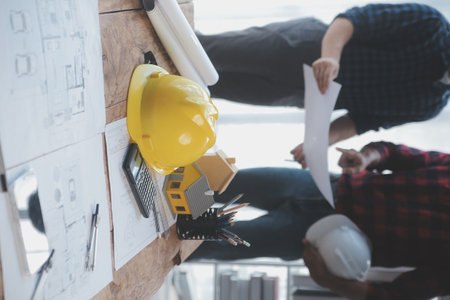 Close up of civil male engineer asian working on blueprint architectural project at construction site at desk in office.の写真素材