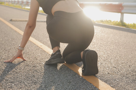 Young lady running on a rural road during sunset