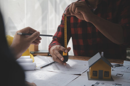 Close up of civil male engineer asian working on blueprint architectural project at construction site at desk in office.の写真素材