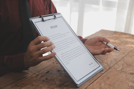 Close up view of job interview in office, focus on resume writing tips, employer reviewing good cv of prepared skilled applicant, recruiter considering application, hr manager making hiring decisionの写真素材