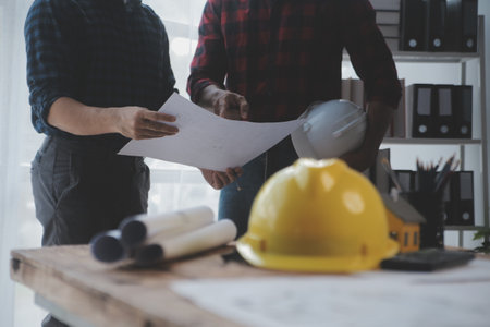 Close up of civil male engineer asian working on blueprint architectural project at construction...