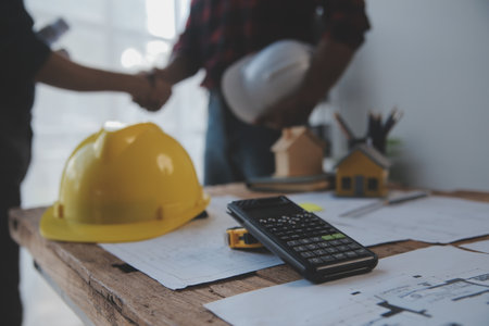 Close up of civil male engineer asian working on blueprint architectural project at construction...