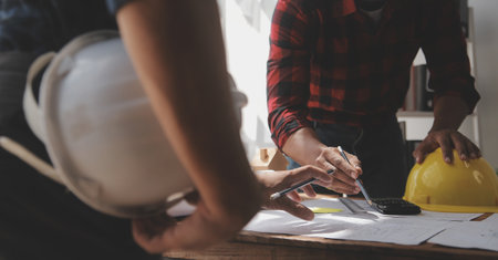 Close up of civil male engineer asian working on blueprint architectural project at construction site at desk in office.の写真素材