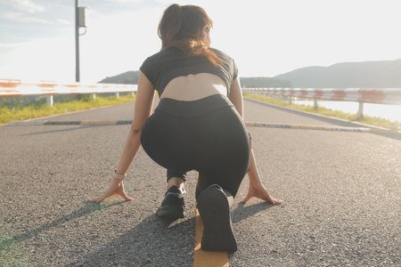 Young lady running on a rural road during sunset