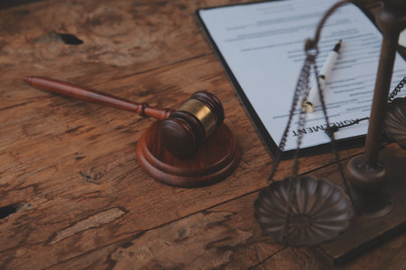 Justice and Law concept. Legal counsel presents to the client a signed contract with gavel and legal law or legal having team meeting at law firm in backgroundの写真素材
