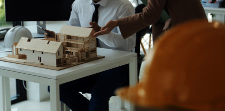 Construction and structure concept of Engineer or architect meeting for project working with partner and engineering tools on model building and blueprint in working site, contract for both companies.の写真素材