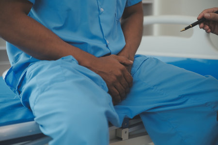 Close up of doctor sitting on bedside of male patient in hospitalの写真素材