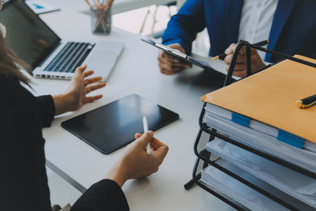 Entrepreneur Asian businessman and businesswoman discussing new business project in tablet in modern Meeting In Modern Office, Asian business casual concept.の写真素材