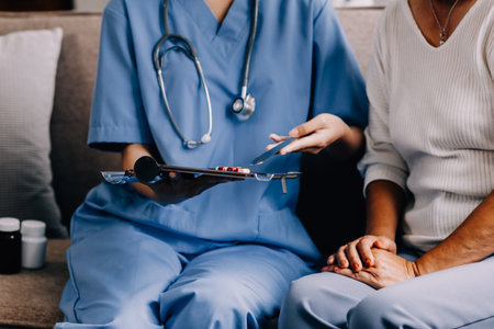 Doctor and patient sitting and talking at medical examination at hospital office, close-up. Therapist filling up medication history records. Medicine and healthcare concept.の写真素材
