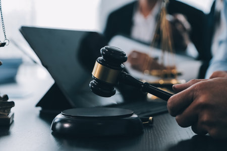 Business and lawyers discussing contract papers with brass scale on desk in office. Law, legal services, advice, justice and law concept picture with film grain effectの写真素材