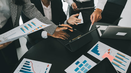 Close up of Business team analyzing income charts and graphs with modern laptop computer. Business...