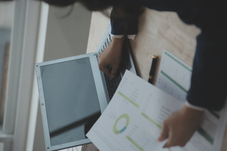 Close up Business woman using calculator and laptop for do math finance on wooden desk, tax,...