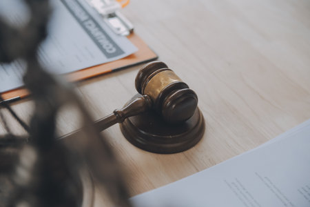 Business and lawyers discussing contract papers with brass scale on desk in office. Law, legal services, advice, justice and law concept picture with film grain effectの写真素材