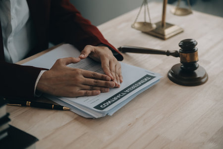 Justice and law concept.Male judge in a courtroom with the gavel, working with, computer and docking keyboard, eyeglasses, on table in morning lightの写真素材