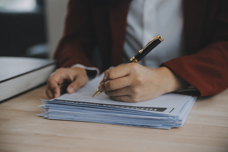 Business and lawyers discussing contract papers with brass scale on desk in office. Law, legal services, advice, justice and law concept picture with film grain effectの写真素材