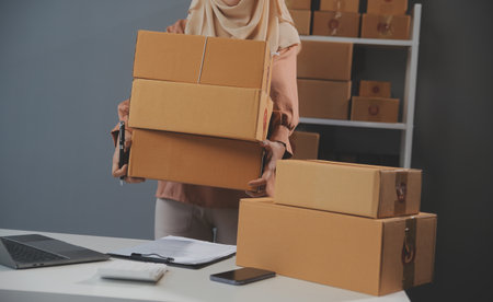 Starting small businesses SME owners female entrepreneurs Write the address on receipt box and check online orders to prepare to pack the boxes, sell to customers, sme business ideas online.の写真素材