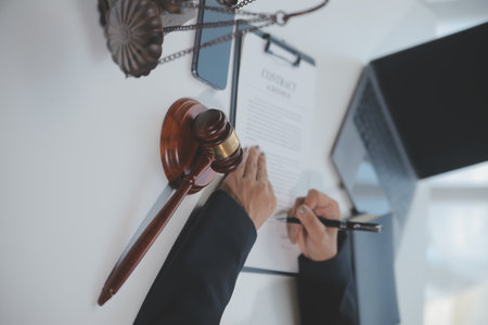 Business and lawyers discussing contract papers with brass scale on desk in office. Law, legal services, advice, justice and law concept picture with film grain effectの写真素材