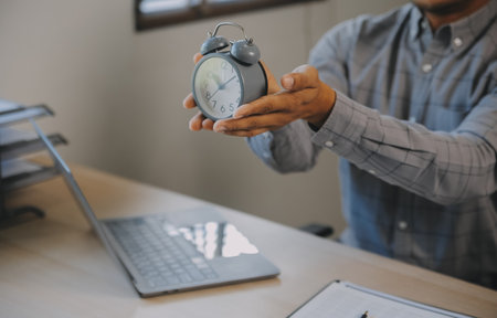 Business working times concept people work typing on laptop computer overlay with in time clock to...