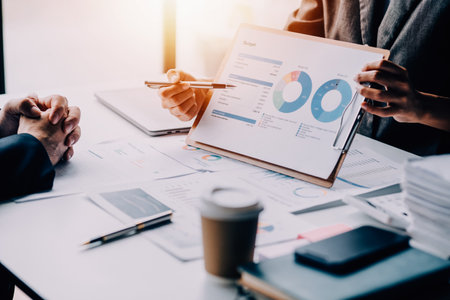 Financial analysts analyze business financial reports on a digital tablet planning investment project during a discussion at a meeting of corporate showing the results of their successful teamwork.の写真素材