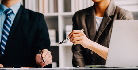 Financial analysts analyze business financial reports on a digital tablet planning investment project during a discussion at a meeting of corporate showing the results of their successful teamwork.の写真素材