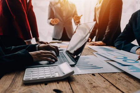 Financial analysts analyze business financial reports on a digital tablet planning investment project during a discussion at a meeting of corporate showing the results of their successful teamwork.の写真素材