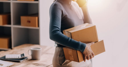 Entrepreneurs Small Business SME Independent men work at home Use smartphones and laptops for commercial checking, online marketing, packing boxes, SME sellers, concept, e-commerce team, online salesの写真素材