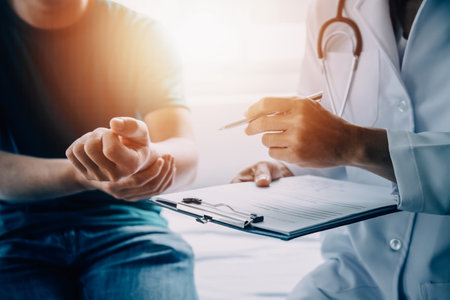 Male patient having consultation with doctor or psychiatrist who working on diagnostic examination on men's health disease or mental illness in medical clinic or hospital mental health service centerの写真素材