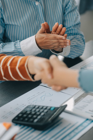 Financial analysts analyze business financial reports on a digital tablet planning investment project during a discussion at a meeting of corporate showing the results of their successful teamwork.の写真素材