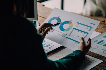Attractive smiling young asian business woman work at home office, Asian woman working on laptop computer holding tablet.の写真素材