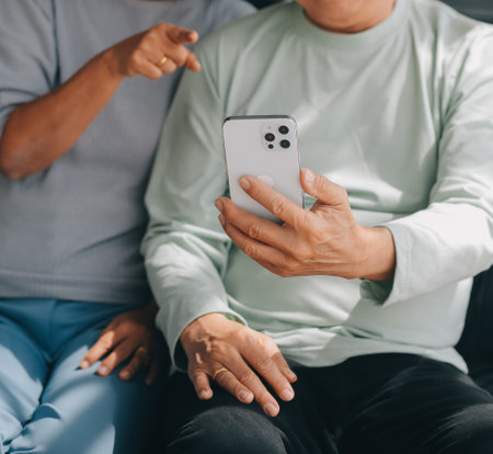 Embraced mature couple surfing the Internet on laptop at homeの写真素材