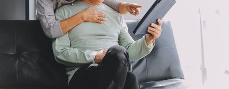 Happy mature couple using laptop at home