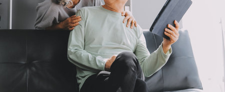 Happy mature couple using laptop at homeの写真素材