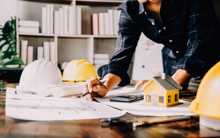 Two Specialists Inspect Commercial, Industrial Building Construction Site. Real Estate Project with Civil Engineer, Investor Use Laptop. In the Background Crane, Skyscraper Concrete Formwork Framesの写真素材