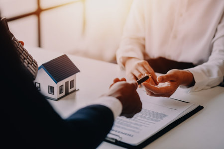 Accountant, businessman, real estate agent, Asian business woman handing keys to customers along with house after customers to signの写真素材