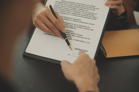 Business and lawyers discussing contract papers with brass scale on desk in office. Law, legal services, advice, justice and law concept picture with film grain effectの写真素材