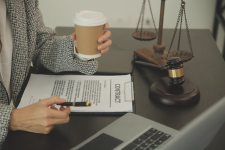Business and lawyers discussing contract papers with brass scale on desk in office. Law, legal services, advice, justice and law concept picture with film grain effectの写真素材
