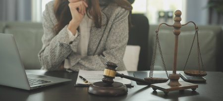 Business and lawyers discussing contract papers with brass scale on desk in office. Law, legal services, advice, justice and law concept picture with film grain effectの写真素材