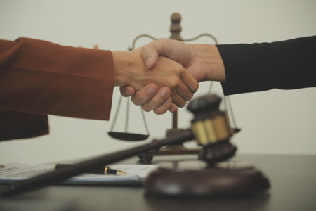 Business and lawyers discussing contract papers with brass scale on desk in office. Law, legal services, advice, justice and law concept picture with film grain effectの写真素材