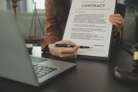 Business and lawyers discussing contract papers with brass scale on desk in office. Law, legal services, advice, justice and law concept picture with film grain effectの写真素材