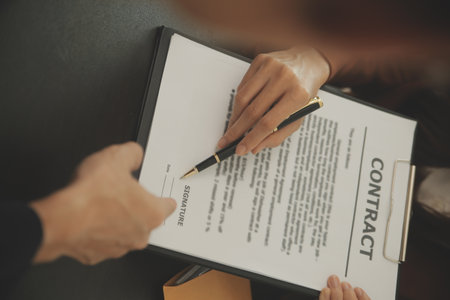 Business and lawyers discussing contract papers with brass scale on desk in office. Law, legal services, advice, justice and law concept picture with film grain effectの写真素材