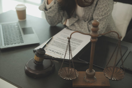 Business and lawyers discussing contract papers with brass scale on desk in office. Law, legal services, advice, justice and law concept picture with film grain effectの写真素材