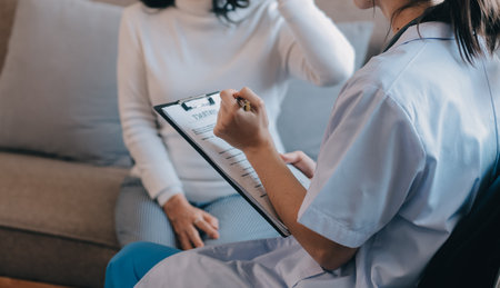 Asian doctor woman visited patient woman to diagnosis and check up health at home or private hospital. Female patient explain health problem and symptoms to doctor .Health care premium service at homeの写真素材
