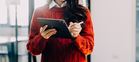 Asian Business woman using calculator and laptop for doing math finance on an office desk, tax, report, accounting, statistics, and analytical research conceptの写真素材