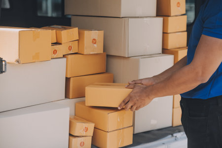 Startup small business entrepreneur of freelance Asian woman using a laptop with box Cheerful success Asian woman her hand lifts up online marketing packaging box and delivery SME idea conceptの写真素材